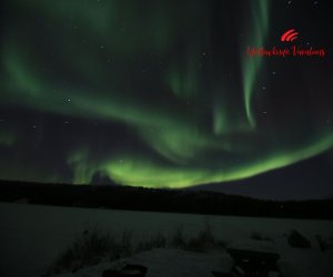 Frozen-lake-and-bright-aurpra-Yellowknife-Vacations